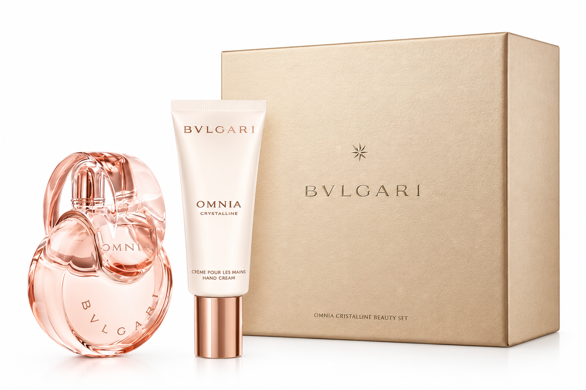 Bvlgari Omnia Crystalline Beauty Gift Set for women, featuring an elegant rose-gold perfume bottle with a sculptural circular design, matching Omnia Crystalline hand cream in a white tube with metallic cap, and a luxurious beige Bvlgari gift box, displayed against a clean white background.