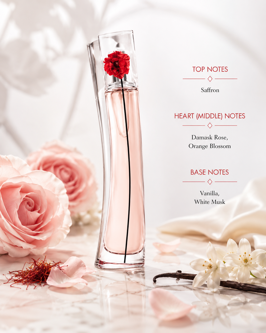 Kenzo Flower by Kenzo L'Absolue, preserving the exact tall curved transparent bottle, pale blush-pink fragrance, clear asymmetric cap, red poppy and long black stem from the reference image. Display the bottle on polished pale marble in an elegant soft blush and ivory setting. Surround naturally with saffron threads; luxurious Damask roses and delicate orange blossoms; vanilla pods and soft white floral elements suggesting white musk. 