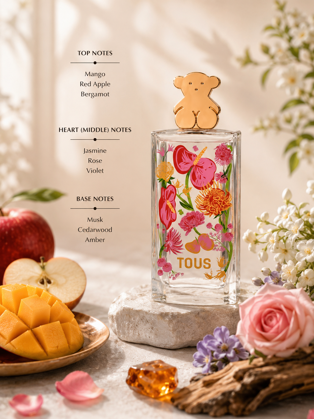 Tous Floral Touch Eau de Toilette displayed with mango, red apple, bergamot, jasmine, rose, violet, cedarwood, and amber accents. Notes shown: Top – mango, red apple, bergamot; Heart – jasmine, rose, violet; Base – musk, cedarwood, and amber. Bright fruity-floral presentation with a fresh, feminine aesthetic.