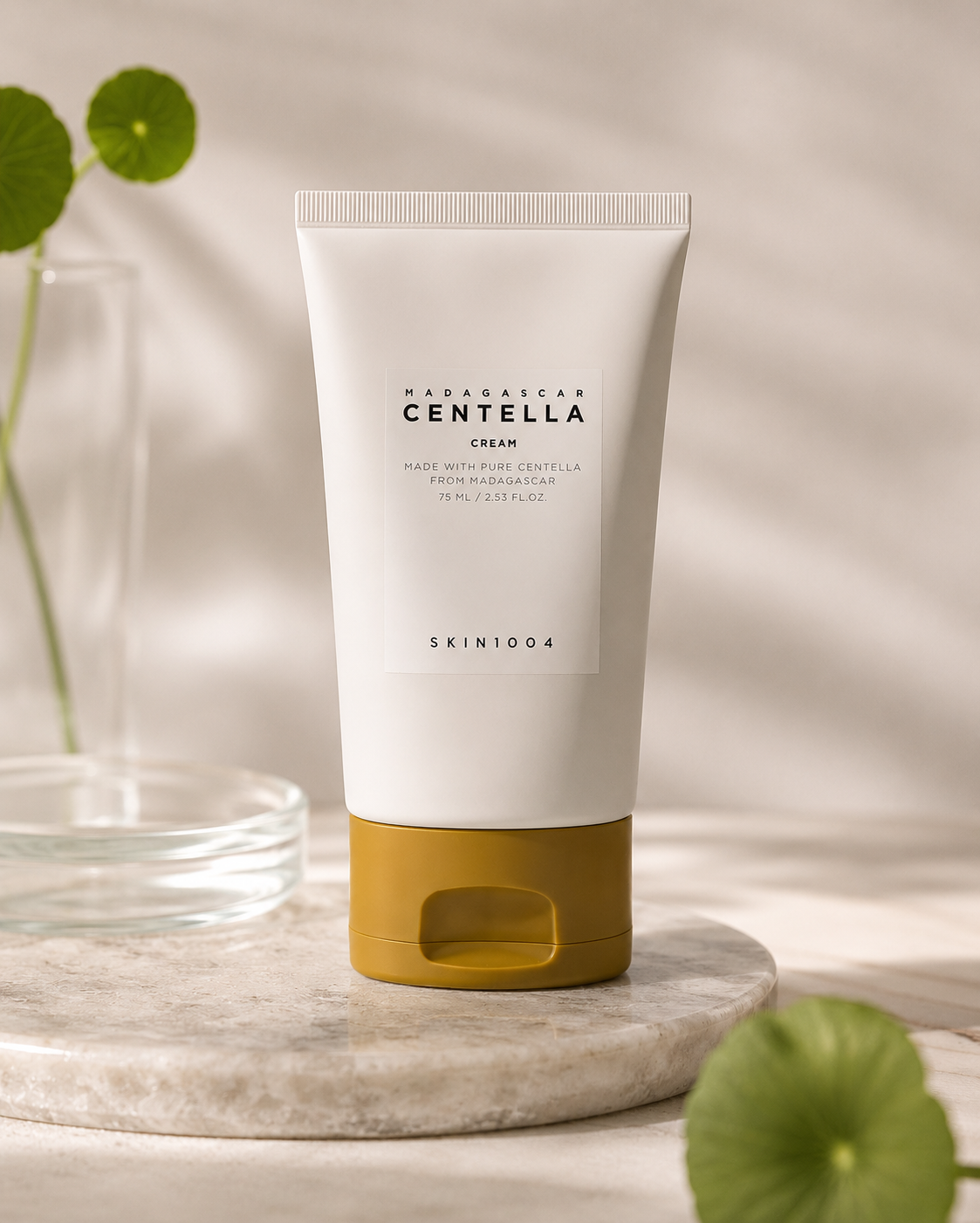 SKIN1004 Madagascar Centella Cream 75ml on a marble surface with green leaves.